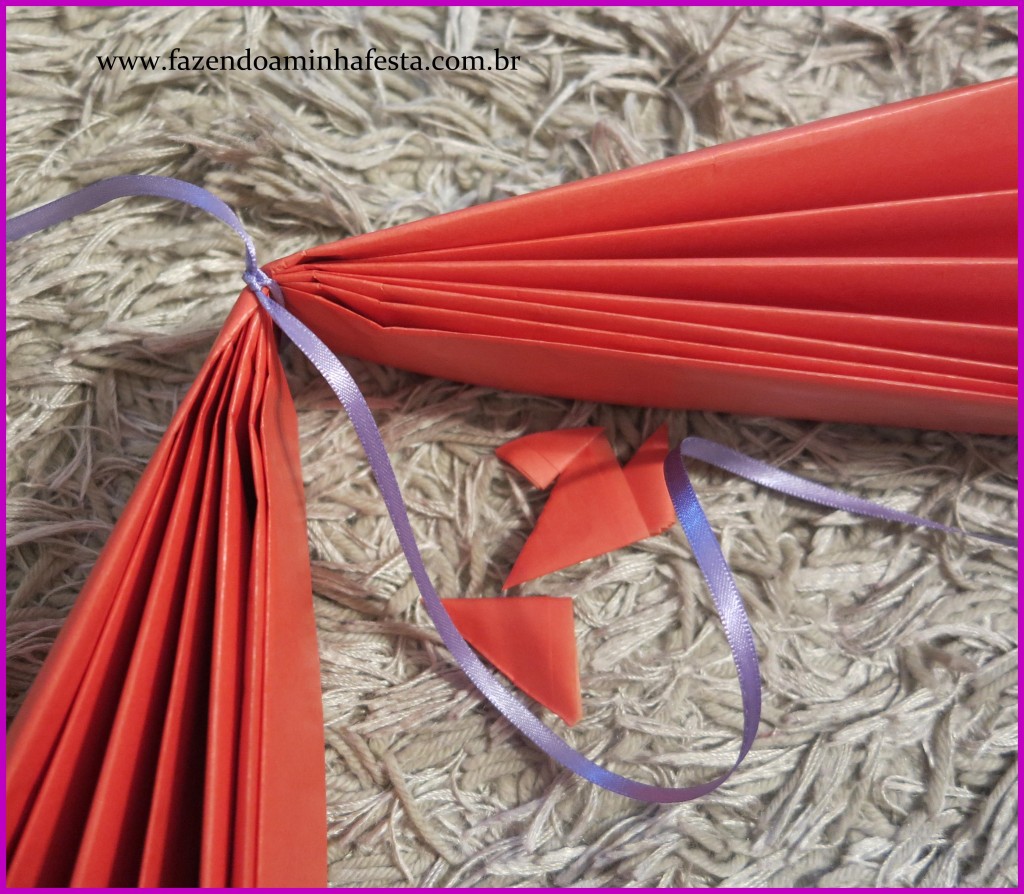 Passo a Passo para fazer Pompons: O nó deve ficar em cima, e não no meio da dobra