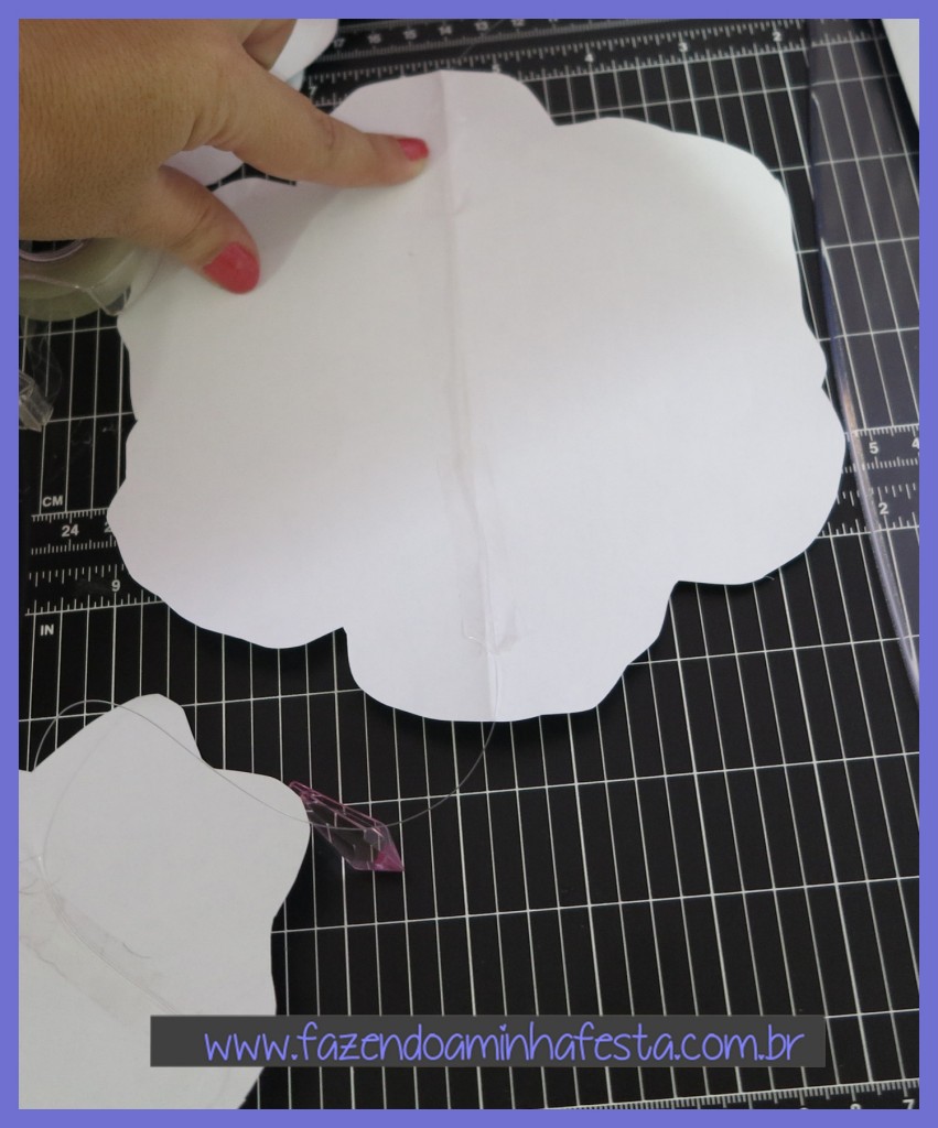 Deixe um espaço de 5 a 10cm de fio e cole em cima do molde grande com fita adesiva.